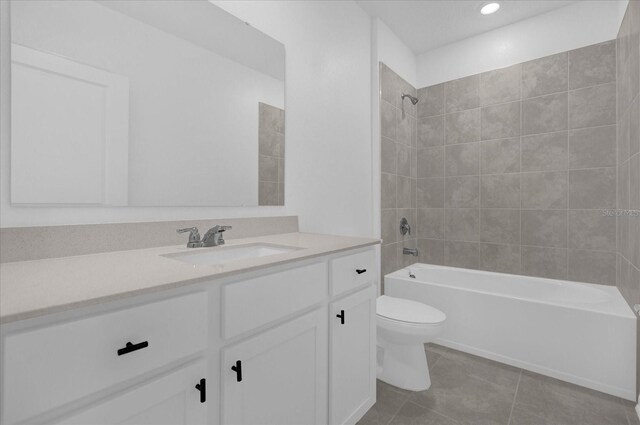 full bathroom featuring toilet, tiled shower / bath combo, vanity, and tile patterned flooring