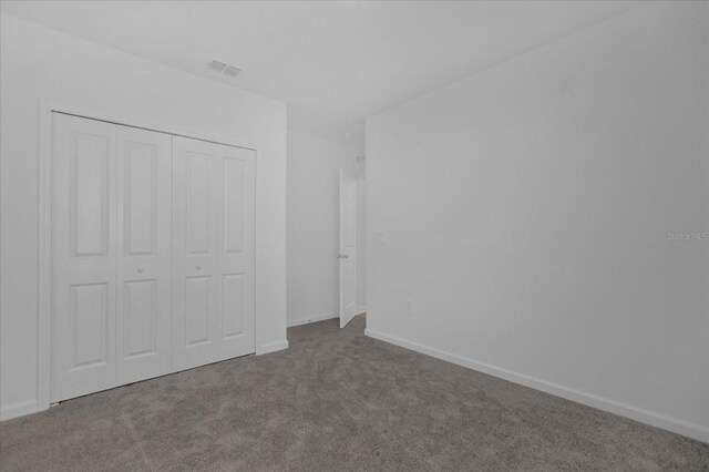 unfurnished bedroom with a closet and carpet floors