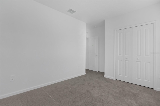 unfurnished bedroom featuring carpet flooring and a closet