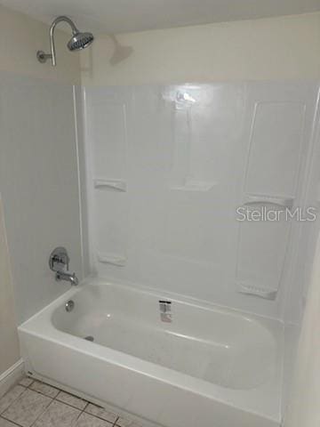 bathroom with tile patterned flooring and washtub / shower combination