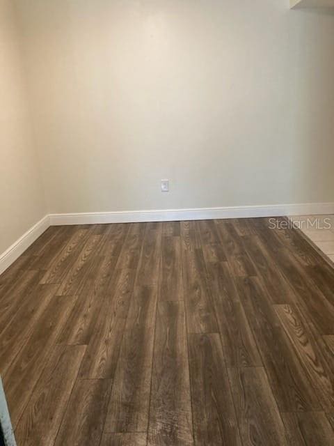 empty room with dark hardwood / wood-style flooring