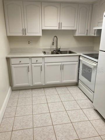 kitchen featuring white appliances, light tile patterned flooring, and sink