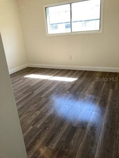 empty room with dark wood-type flooring