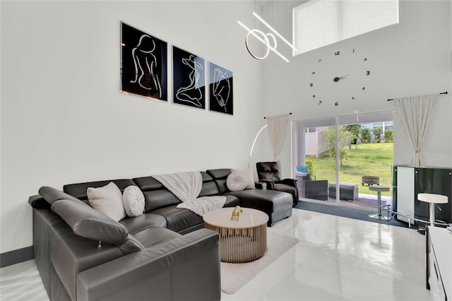 living room featuring a towering ceiling and concrete flooring