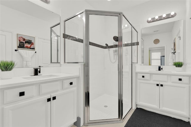 bathroom with a shower with shower door and vanity