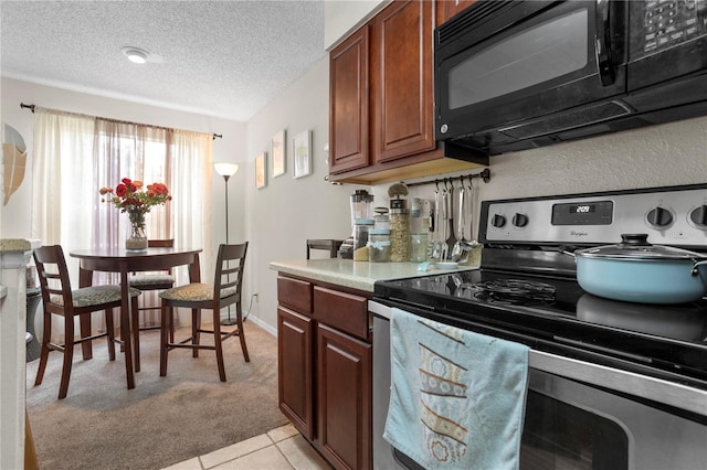 kitchen with a textured ceiling, stainless steel electric range oven, and light tile patterned floors