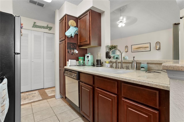 kitchen with light tile patterned flooring, sink, dishwasher, ceiling fan, and stainless steel fridge