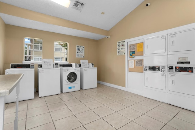 clothes washing area featuring washing machine and dryer, stacked washer and clothes dryer, and light tile patterned floors