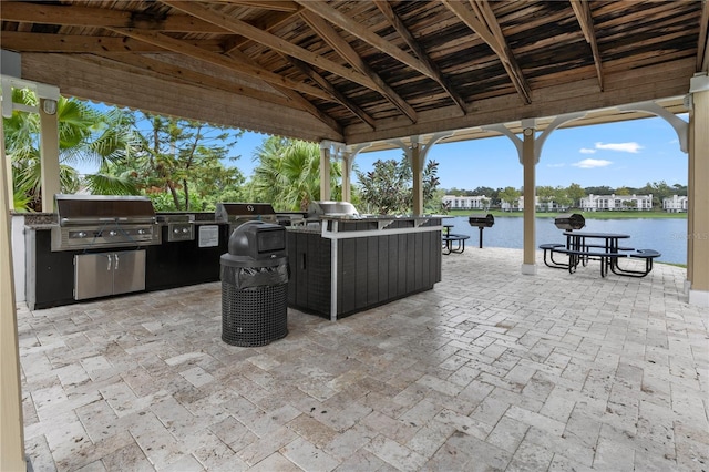 view of patio / terrace with a gazebo, an outdoor kitchen, a grill, and a water view