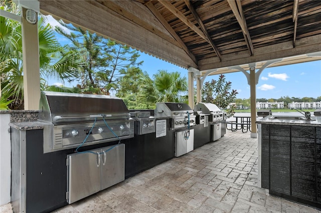 view of patio featuring exterior kitchen and a grill