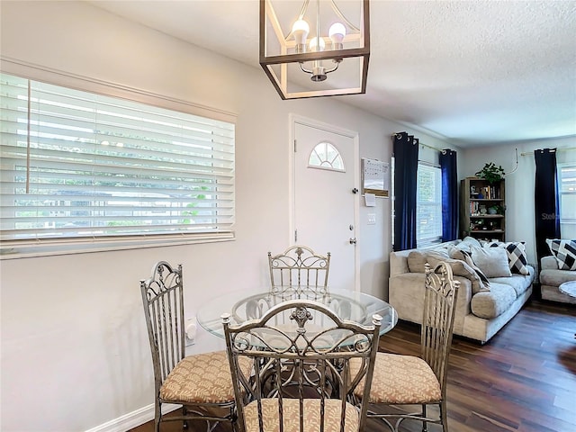 dining room featuring dark hardwood / wood-style floors, an inviting chandelier, and a textured ceiling