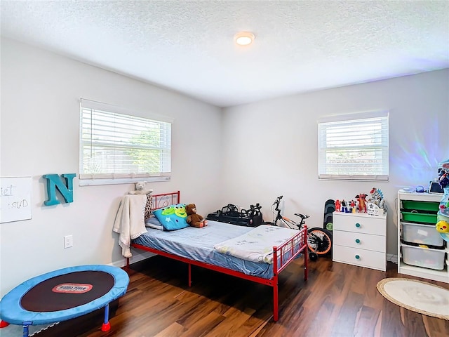 bedroom featuring dark wood-type flooring and a textured ceiling