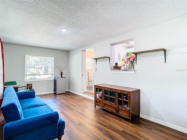 living room with dark hardwood / wood-style floors and a textured ceiling