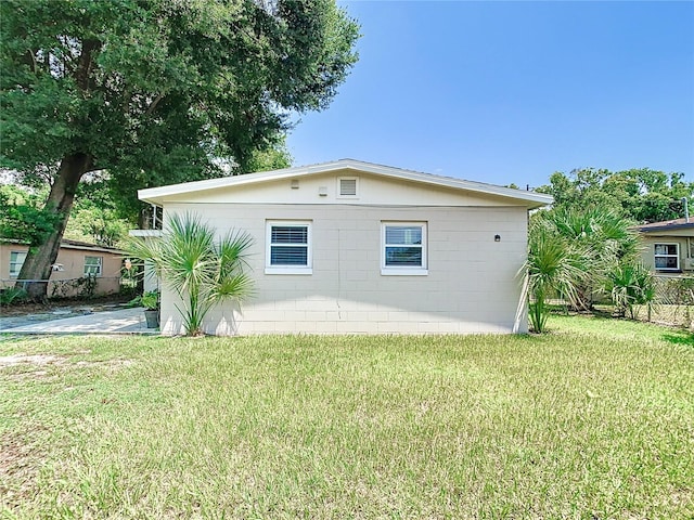 view of side of home with a yard