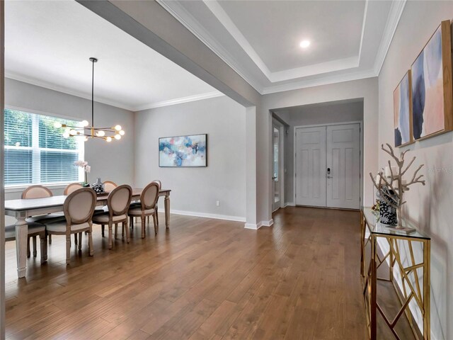 dining space featuring hardwood / wood-style flooring, ornamental molding, and a chandelier