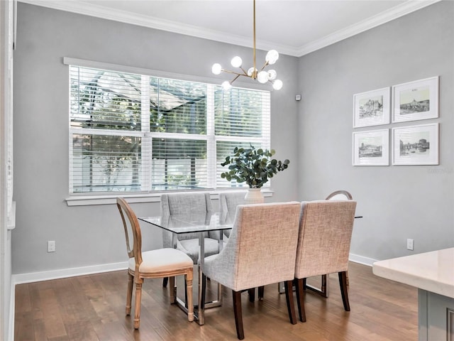 dining space with hardwood / wood-style flooring, ornamental molding, a healthy amount of sunlight, and a notable chandelier