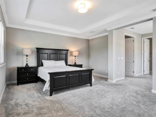 carpeted bedroom featuring a tray ceiling and ornamental molding