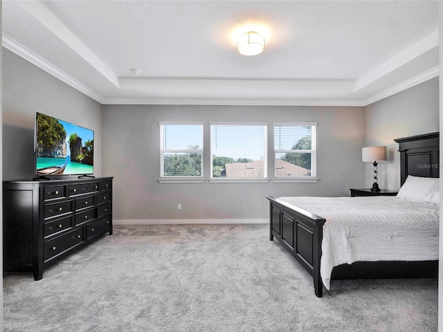 carpeted bedroom with ornamental molding, a raised ceiling, and multiple windows