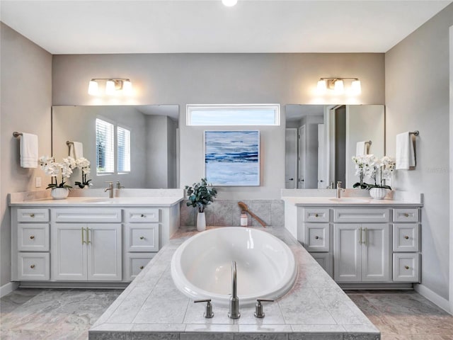 bathroom with a relaxing tiled tub and vanity