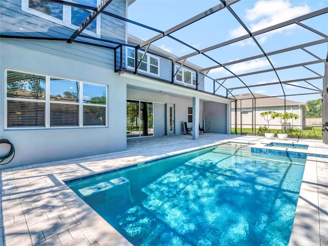 view of swimming pool featuring an in ground hot tub, a patio, and glass enclosure