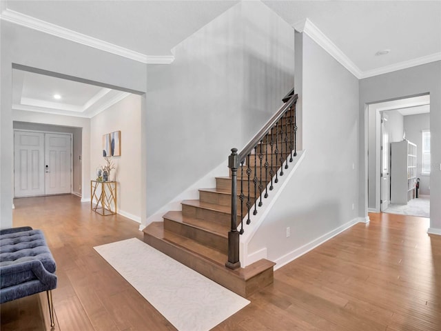 entryway with ornamental molding and light hardwood / wood-style floors