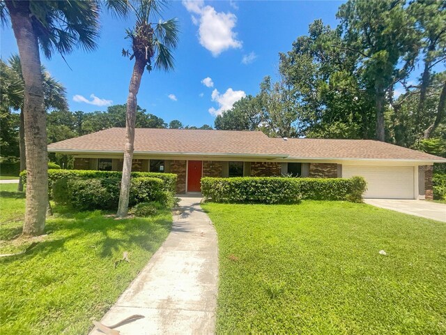 single story home featuring a garage and a front yard