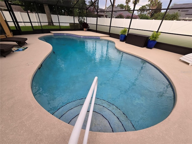 view of swimming pool featuring glass enclosure and a patio area