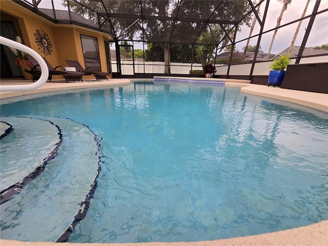 view of swimming pool featuring glass enclosure