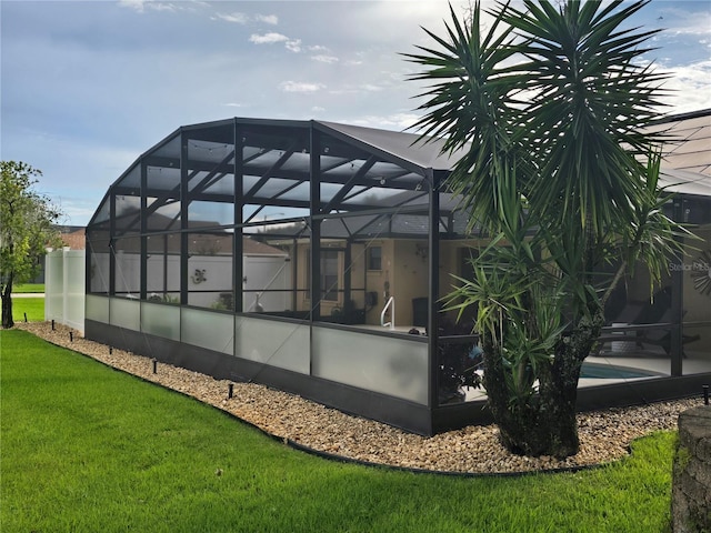 view of home's exterior featuring a lanai and a yard