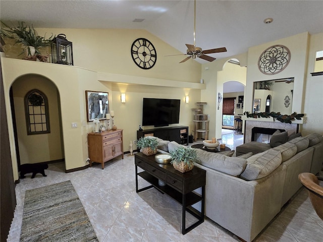 tiled living room featuring ceiling fan and high vaulted ceiling