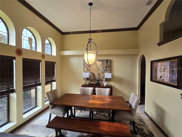 dining space featuring a high ceiling and crown molding