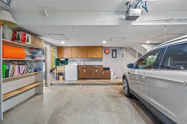 garage with a garage door opener, washer / dryer, and sink