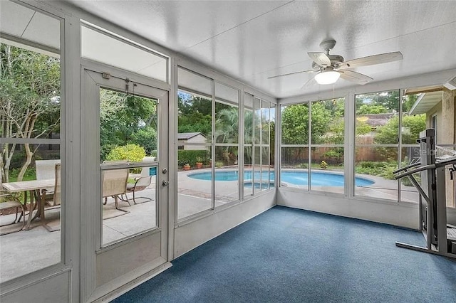 unfurnished sunroom with ceiling fan