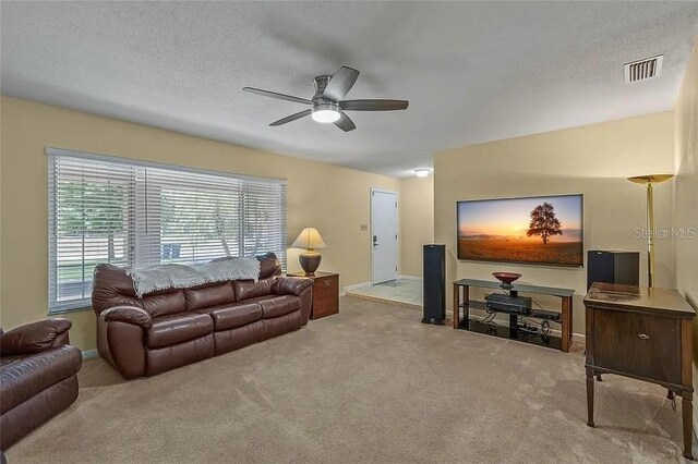 carpeted living room featuring a textured ceiling and ceiling fan