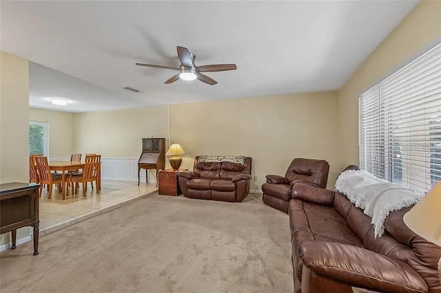 carpeted living room with ceiling fan