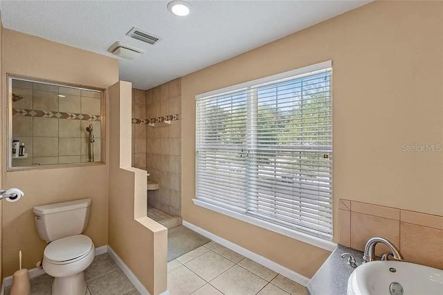 bathroom with toilet, plus walk in shower, and tile patterned flooring