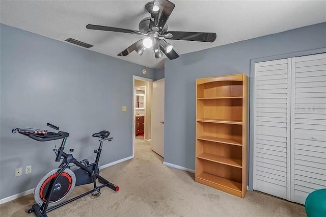 exercise area with ceiling fan and light carpet