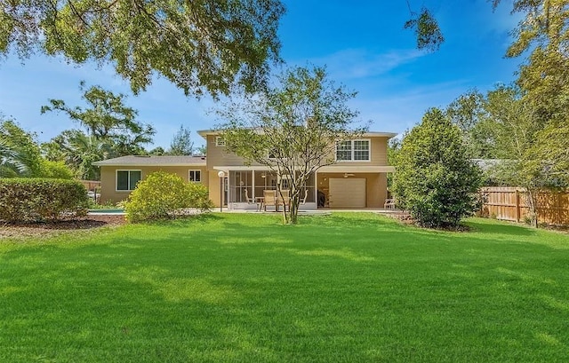 back of property featuring a garage and a yard