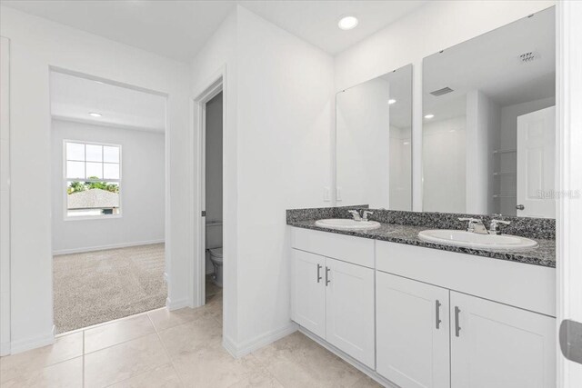 bathroom featuring tile patterned floors, vanity, and toilet