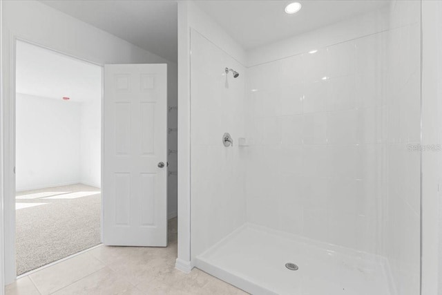 bathroom featuring tile patterned flooring and tiled shower