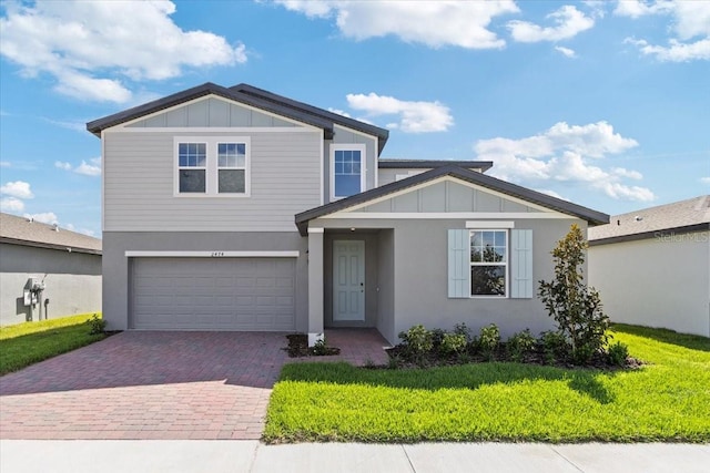 view of front of property featuring a garage and a front lawn