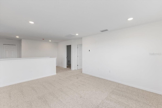 spare room featuring light colored carpet