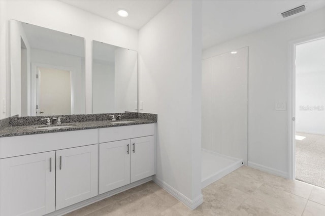 bathroom featuring vanity, a shower, and tile patterned flooring