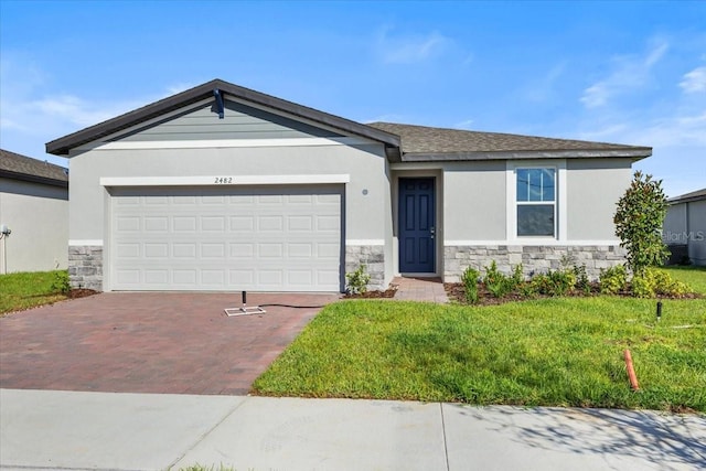 ranch-style house with stone siding, a front lawn, stucco siding, and decorative driveway
