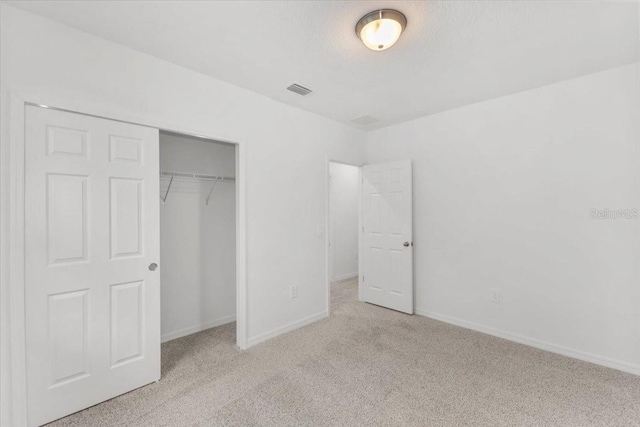 unfurnished bedroom featuring baseboards, a closet, and carpet