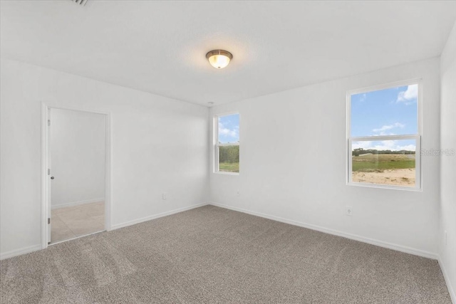 carpeted spare room featuring baseboards