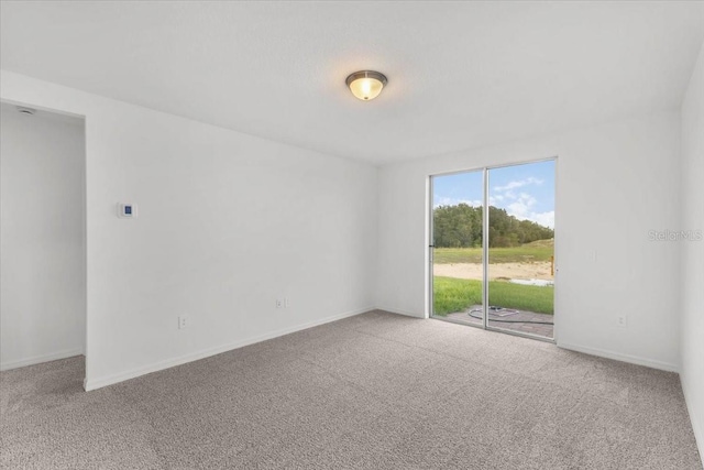 carpeted empty room with baseboards