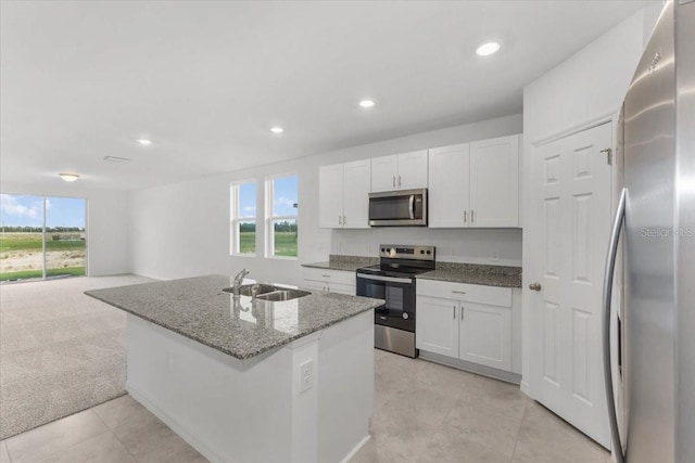 kitchen with plenty of natural light, white cabinetry, stainless steel appliances, and a sink