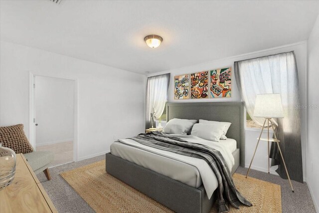 bedroom with baseboards, carpet flooring, and multiple windows