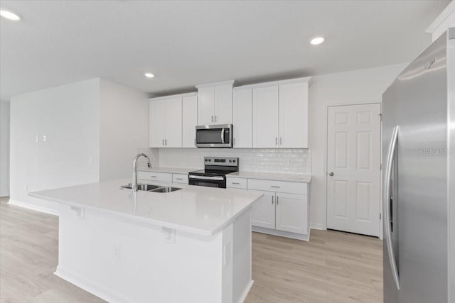 kitchen featuring appliances with stainless steel finishes, light hardwood / wood-style floors, white cabinetry, and sink